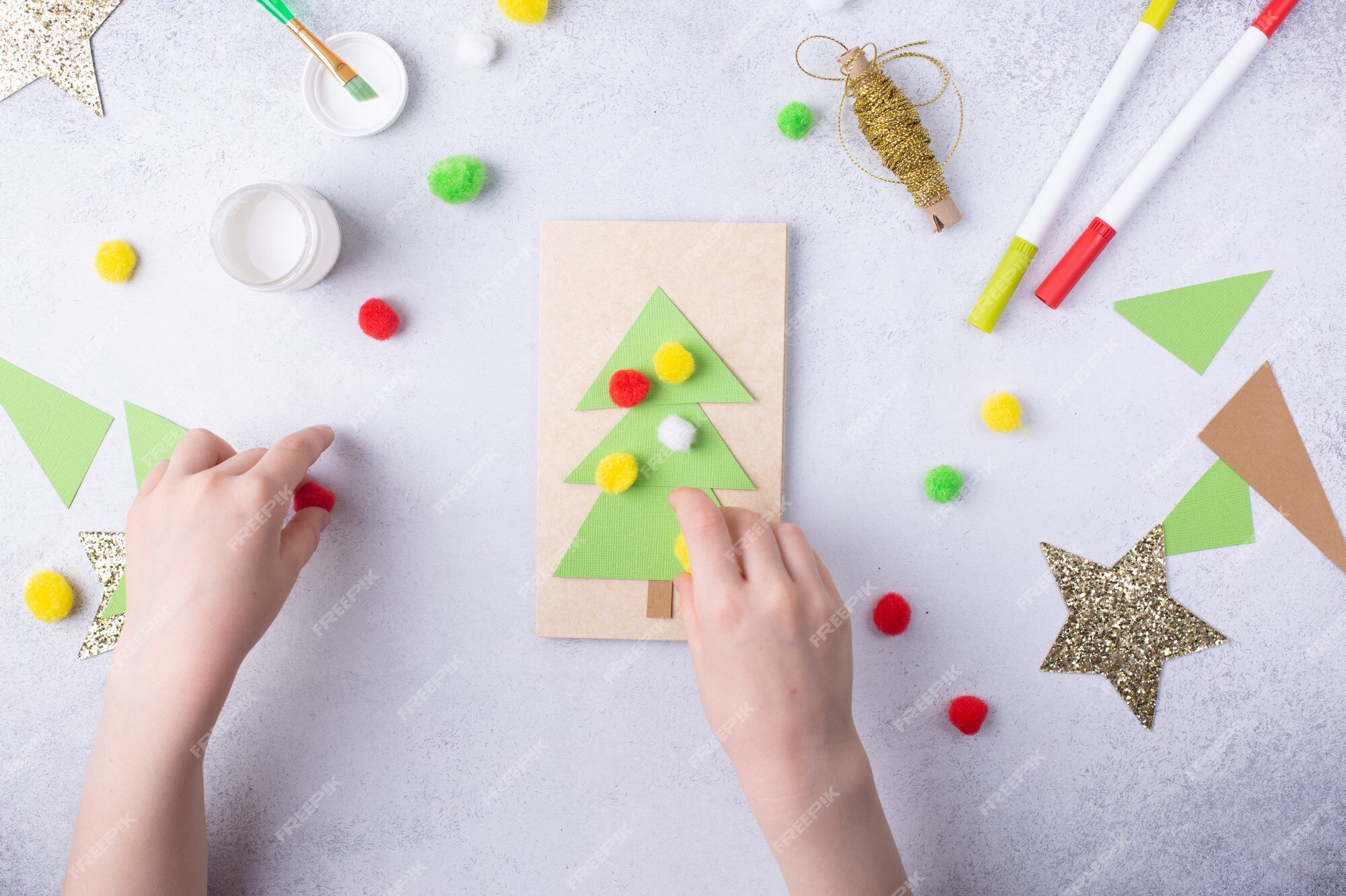 A criança faz um cartão de felicitações colagem de papel de natal, projeto  de arte infantil, para crianças foto de alta qualidade