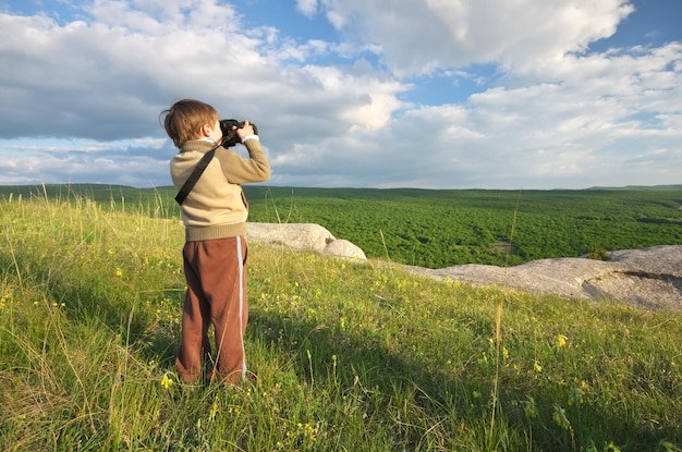 A criança fotografa a natureza