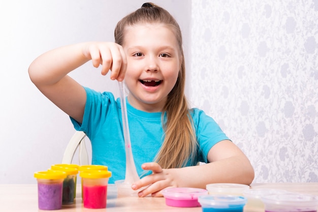 A criança loira está brincando com muco