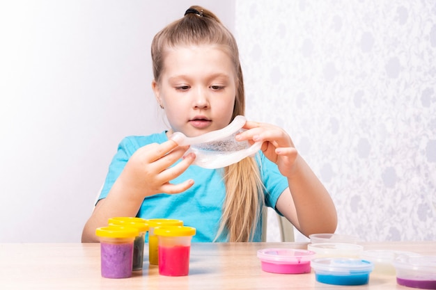 A criança loira está brincando com muco