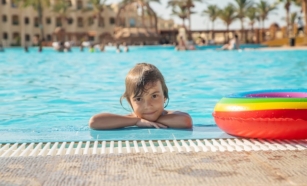 A criança nada e mergulha na piscina. foco seletivo. natureza.