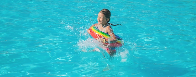 A criança nada e mergulha na piscina. foco seletivo.