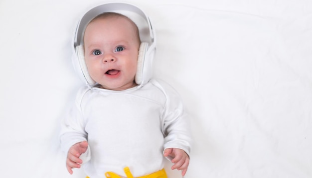 A criança ouve música com fones de ouvido em um fundo branco