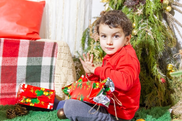 a criança pequena brincando com decorações de Natal no estúdio criança pequena com bola de Natal