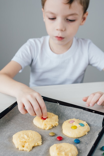 A criança prepara biscoitos caseiros de Natal