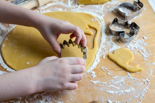 A criança prepara biscoitos caseiros