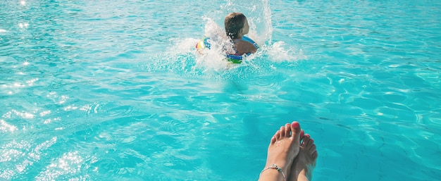 A criança pula na piscina. Foco seletivo. natureza.