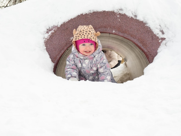 A criança se diverte no inverno no playground