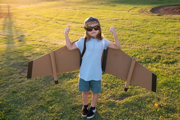 A criança super-heroína poderosa mostra os músculos que o menino sonha em voar despreocupado, brincando ao ar livre e viajando