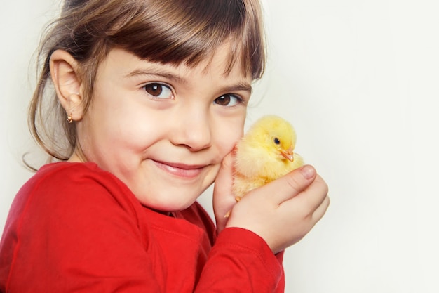 A criança tem um frango nas mãos. Foco seletivo.