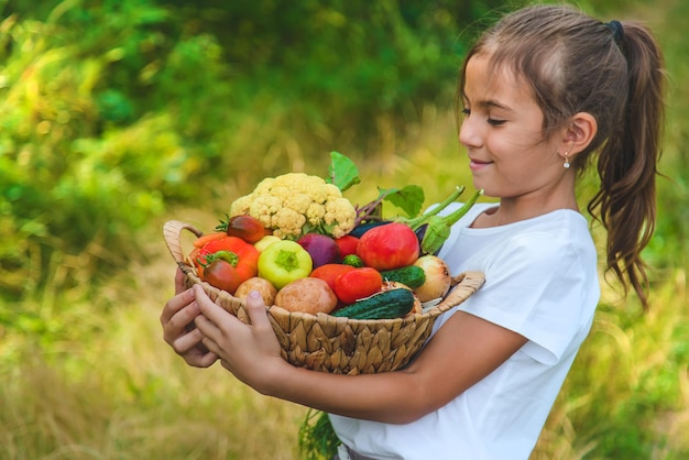 A criança tem vegetais nas mãos. Foco seletivo. Criança.