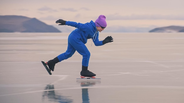 A criança treina no gelo patinação de velocidade profissional A menina patina no inverno no sportswear esporte óculos terno Crianças patinação de velocidade curta longa pista esporte infantil Câmera lenta ao ar livre