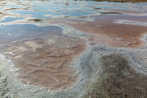 A crosta de sal no fundo do lago seco de lama curativa. A superfície do lago salgado.