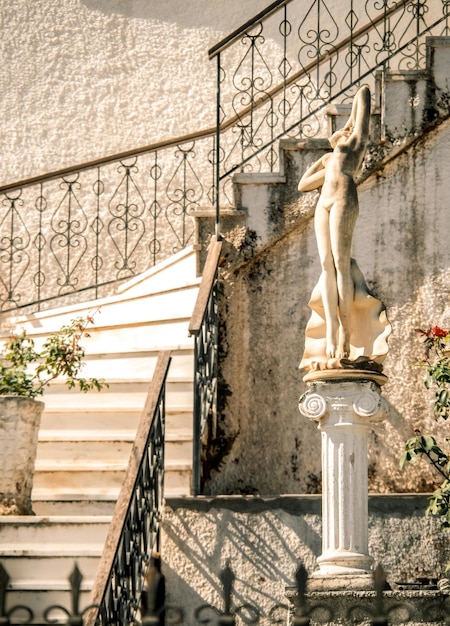 A decoração do pátio de uma casa grega com degraus de mármore e uma estátua na ilha da grécia