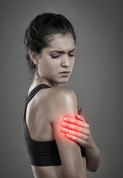 A dor faz parte do processo Foto de estúdio de uma jovem atraente segurando seu braço ferido que é mostrado através de CGI
