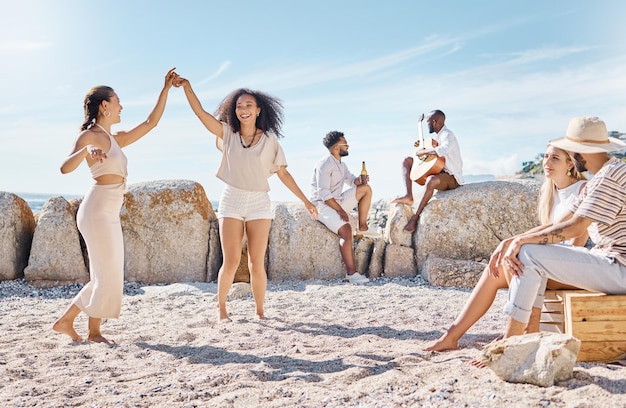 A ela para meus nanigans. Foto de duas jovens dançando na praia com seus amigos.