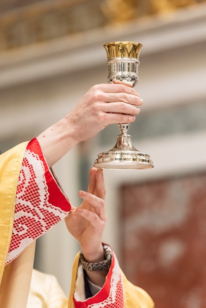 A elevação do cálice com o vinho sacramental durante a liturgia católica da eucaristia