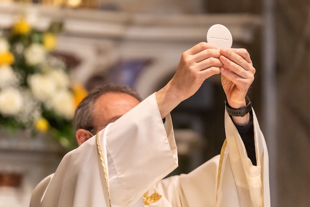 A elevação do pão sacramental durante a liturgia católica