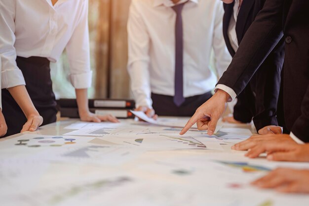 A empresa gasta tempo planejando um novo projeto financeiro com a equipe de brainstorming enquanto está sentada à mesa do escritório. Conceitos de negócios, gestão, planejamento, equipe, trabalho, reuniões e saudação.