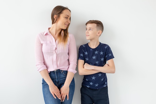 A encantadora jovem mãe e um lindo filho positivo ficam felizes olhando um para o outro enquanto estão na nova sala de estar após a mudança