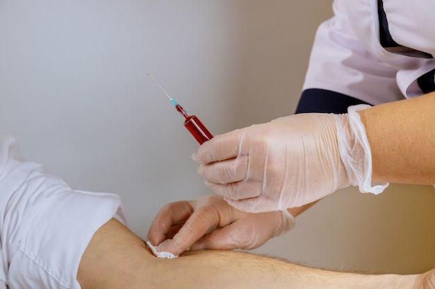 A enfermeira de luvas de remédio coleta o sangue para o tubo de ensaio, amostra de sangue humano para covid-19