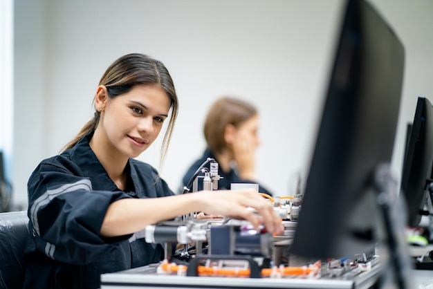 A engenheira verifica e controla a máquina de braços robóticos de automação em uma fábrica inteligente industrial em tempo real, robótica de software de sistema de monitoramento e operação de fabricação digital