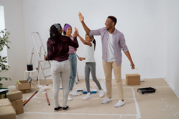 A equipe da família trabalha em conjunto durante a reforma do apartamento kids highfive