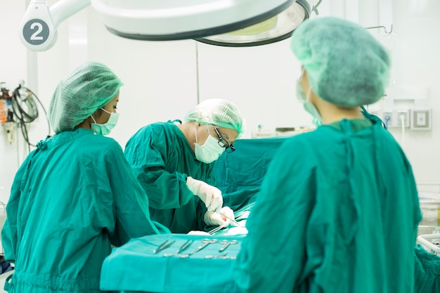 Foto a equipe de cirurgia trabalhando juntos na sala de cirurgia no hospital