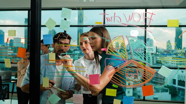 A equipe de negócios faz um brainstorming de ideias enquanto o líder escreve em post-its Tracery