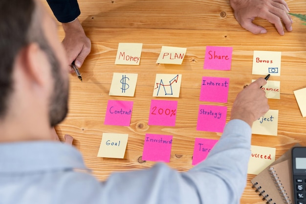 A equipe de negócios se reúne na mesa para fazer um brainstorming e escrever ideias criativas com fervor