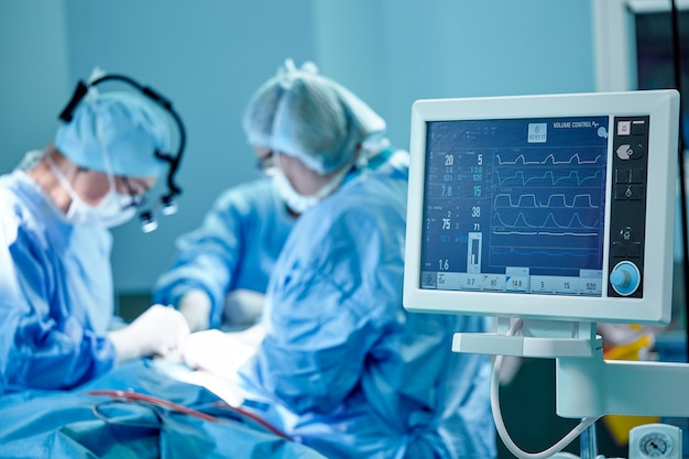 Foto a equipe de um cirurgião de uniforme realiza uma operação em um paciente em uma clínica de cirurgia cardíaca. medicina moderna, uma equipe profissional de cirurgiões, saúde.