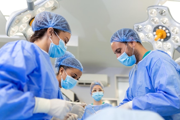 A equipe de um cirurgião de uniforme realiza uma operação em um paciente em uma clínica de cirurgia cardíaca Medicina moderna uma equipe profissional de saúde de cirurgiões