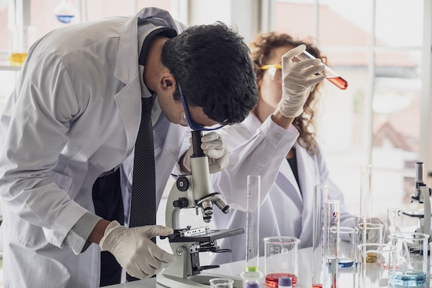 A equipe do cientista da pesquisa médica conduz experiências no laboratório.