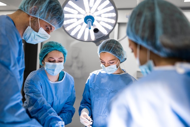A equipe do cirurgião de uniforme realiza uma operação em um paciente em uma clínica de cirurgia cardíaca Medicina moderna uma equipe profissional de cirurgiões de saúde