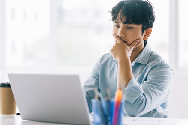 A equipe masculina asiática está completando atentamente o trabalho atribuído