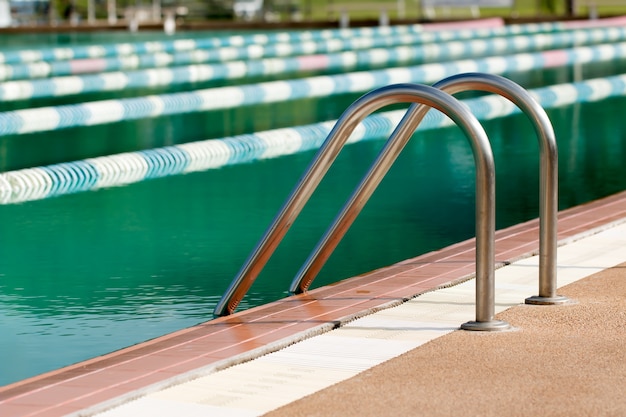 A escada de aço da piscina no dia