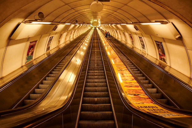 A escada rolante iluminada de uma estação de metrô de Praga fornece um modo eficiente de transporte público