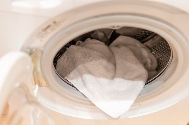A escotilha de lavagem Máquina de lavar roupa branca para roupa com toalha felpuda branca