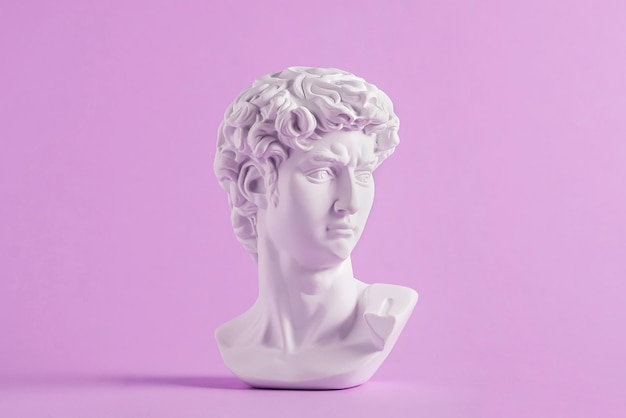 A estátua antiga é a cabeça de David no fundo roxo Conceito de cultura e vaporwave