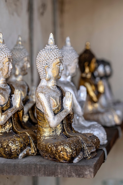 A estátua de Buda figura uma lembrança em exposição à venda no mercado de rua em Ubud, Bali, Indonésia. Vitrine de loja de artesanato e souvenirs, de perto