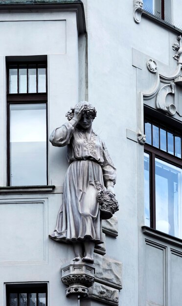 A estátua de uma mulher está ao lado de um prédio.