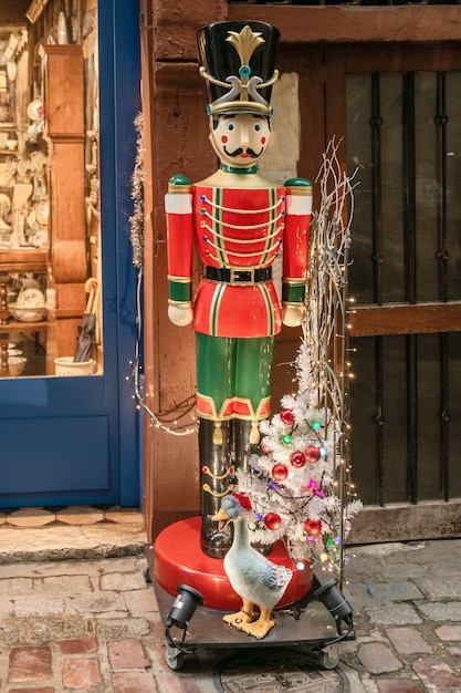 A estátua do Quebra-nozes perto de lojas de decoração de Natal