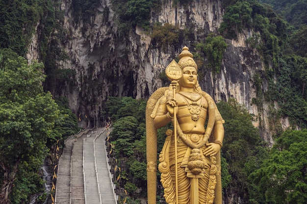 Foto a estátua do senhor murugan das cavernas de batu e a entrada perto de kuala lumpur, malásia. um afloramento de calcário localizado ao norte de kuala lumpur, batu caves tem três cavernas principais com templos e santuários hindus