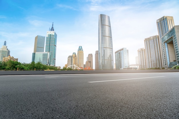 A estrada de asfalto vazia é construída ao longo de edifícios comerciais modernos nas cidades da China.