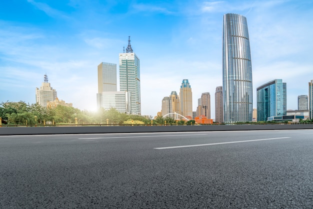 A estrada de asfalto vazia é construída ao longo de edifícios comerciais modernos nas cidades da China.