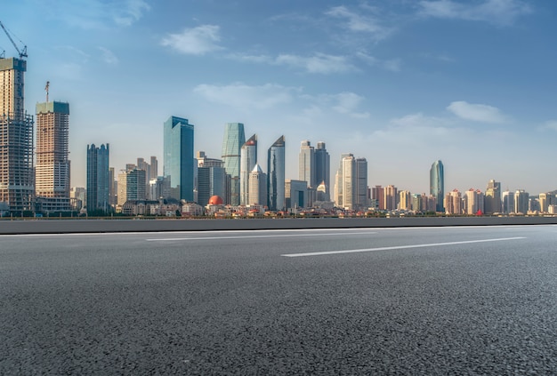 A estrada de asfalto vazia é construída ao longo de edifícios comerciais modernos nas cidades da china.