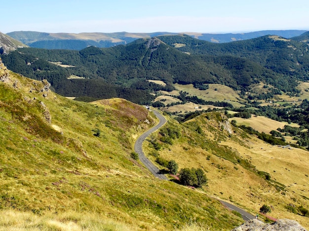 A estrada estreita serpenteia através da cadeia de montanhas de antigos vulcões no fundo