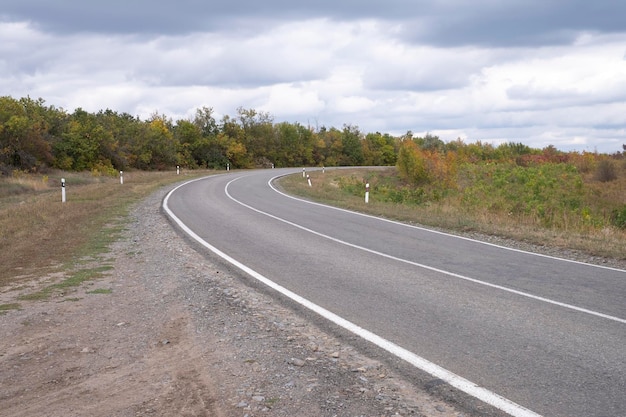 A estrada fazendo uma curva, tempo de outono.