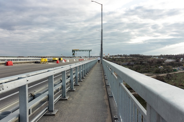 A estrada que se estende para longe na ponte, Ucrânia, Zaporozhye.