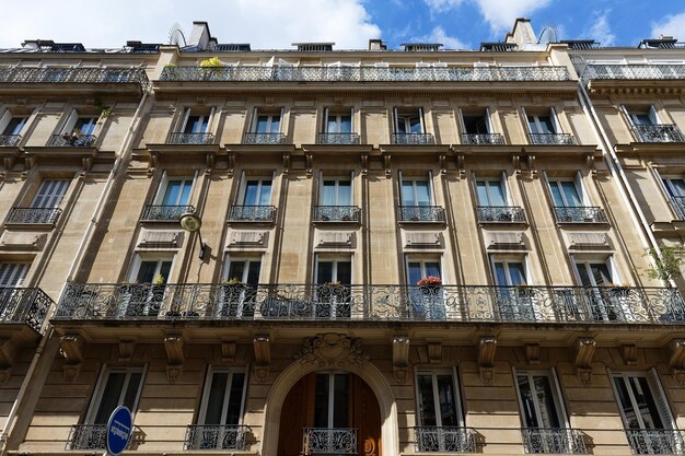 A fachada da casa tradicional francesa com varandas e janelas típicas Paris